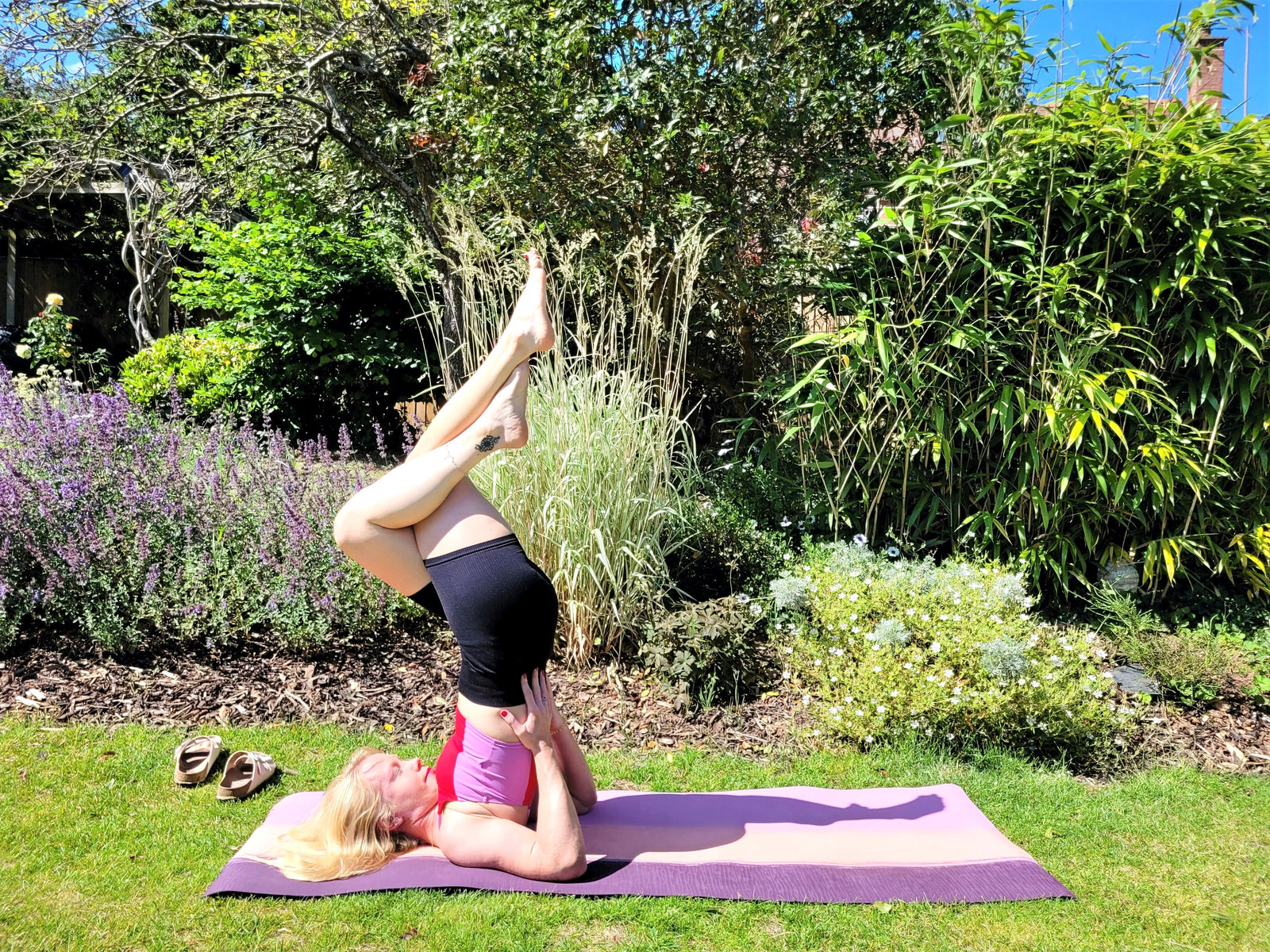 Shoulder stand with eagle legs demonstrated as an advanced post-run yoga counter-pose