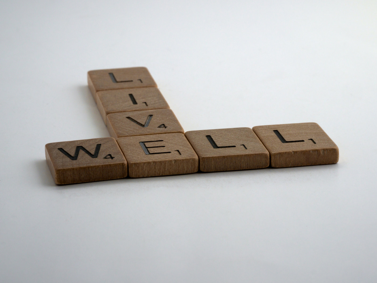 Wooden Scrabble tiles arranged to spell the words live well
